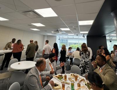 Attendees networking at a speaking event featuring Dr. Glay